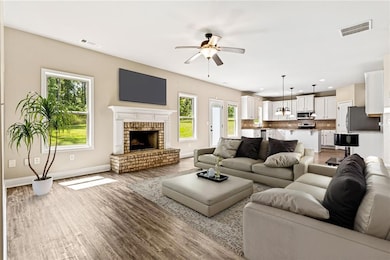 Living room featuring ceiling fan, healthy amount of natural light, wood finished floors, a fireplace, and recessed lighting