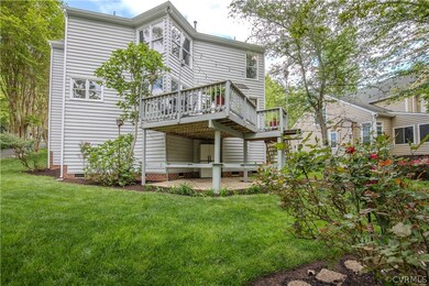 Rear view of house with a deck, a yard, and a pati