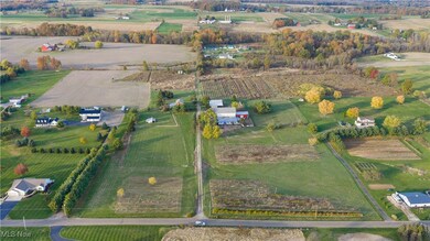 Aerial view of property and surrounding area featuring rows of crops and rural landscape