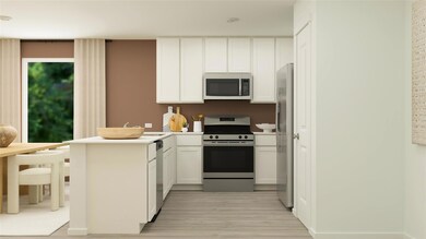 Kitchen featuring stainless steel appliances, kitchen peninsula, light hardwood / wood-style flooring, and white cabinets