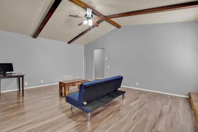 Living room featuring high vaulted ceiling, beamed