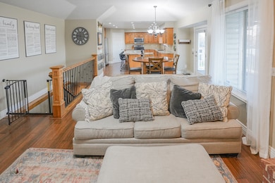 Living area with dark wood finished floors, a chandelier, and recessed lighting