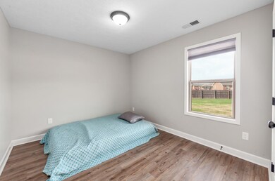Bedroom featuring wood finished floors, baseboards