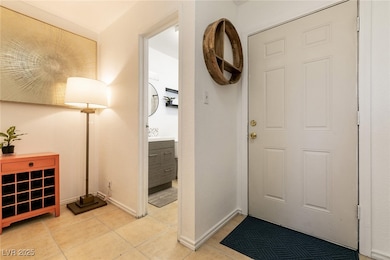 Foyer featuring light tile patterned flooring and baseboards