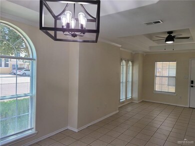 Unfurnished dining area with light tile patterned floors, a raised ceiling, plenty of natural light, a chandelier, and ornamental molding