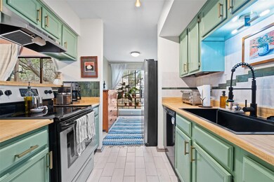 Kitchen with green cabinetry, appliances with sta