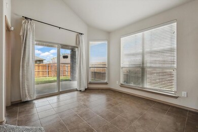 Spare room with baseboards, vaulted ceiling, and t