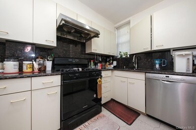Kitchen featuring black gas range oven, dishwasher, ventilation hood, dark stone countertops, and decorative backsplash