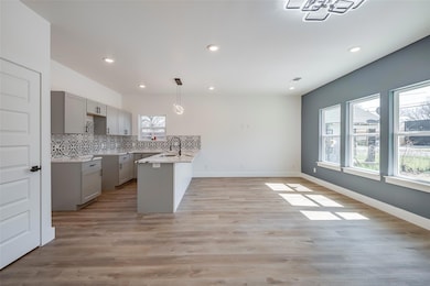 Kitchen featuring decorative backsplash, gray cabi