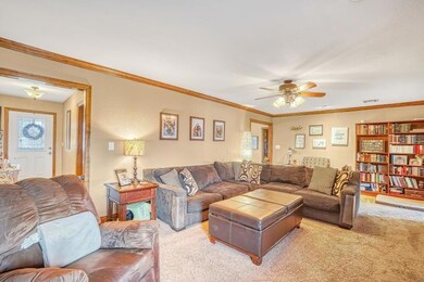 Living room with ornamental molding, light colored