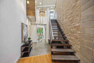 Stairway featuring a towering ceiling, a chandeli