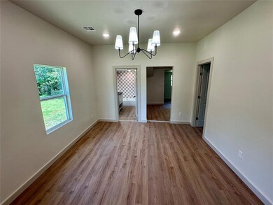 Unfurnished dining area with a chandelier, wood finished floors, and baseboards