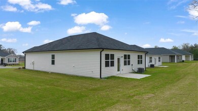 Rear view of property featuring a yard and a patio area