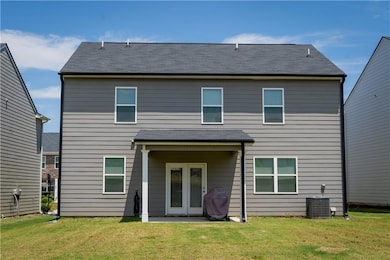 Back of property featuring a lawn, a shingled roof, and a patio