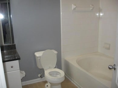 Bathroom featuring toilet, baseboards, vanity, and