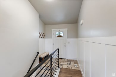 Doorway to outside with wainscoting and stone finish floors