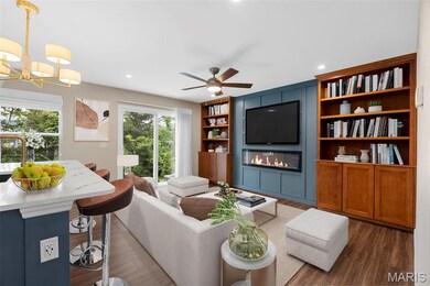 Great room featuring a large fireplace, wood finished floors, a chandelier, ceiling fan, and recessed lighting. Virtually staged.