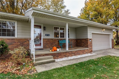 View of front of property with brick siding, a porch, a garage, and concrete driveway