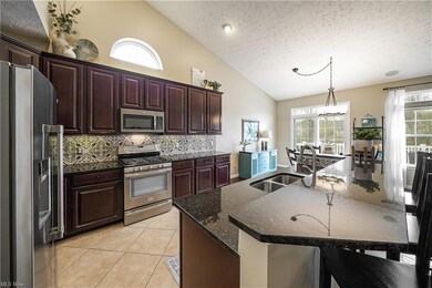 Dream kitchen with granite, attractive backsplash, breakfast bar, stainless appliances & closet pantry...