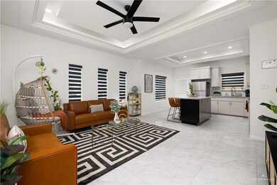 Tiled living room with ceiling fan, a raised ceiling, and sink