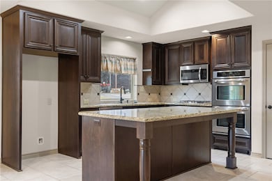 Kitchen with stainless steel appliances, dark brow