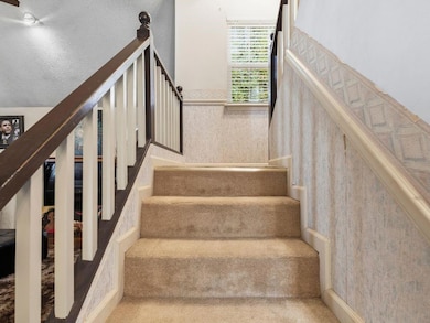 Stairs with a textured ceiling and wainscoting