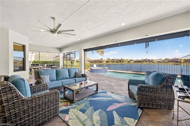View of patio with an outdoor hangout area, ceiling fan, a water view, a pool with connected hot tub, and a residential view