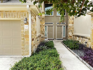 Property entrance with stone siding and a garage