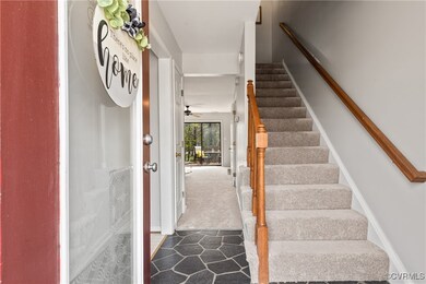 Stairs featuring ceiling fan and carpet flooring