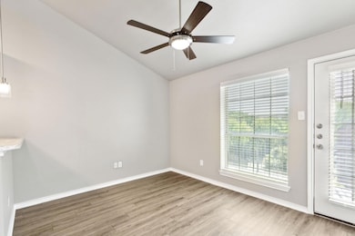 Living room with vaulted ceilings and a ceiling fa
