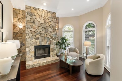 Sunken sitting room featuring bay window and stone fireplace