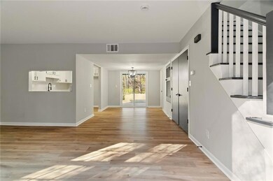 Foyer featuring stairway, a chandelier, light wood