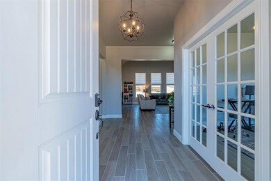 Entryway featuring a notable chandelier, dark wood