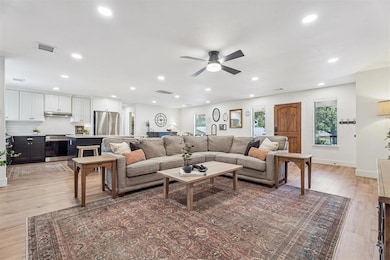 Living room with light wood-style flooring, plenty of natural light, recessed lighting, and ceiling fan