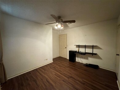 Guest bedroom with ceiling fan, dark wood-style fl
