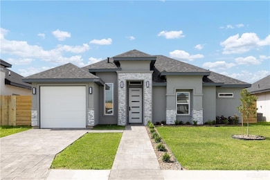 Prairie-style home with stucco siding, decorative driveway, fence, a front lawn, and a garage