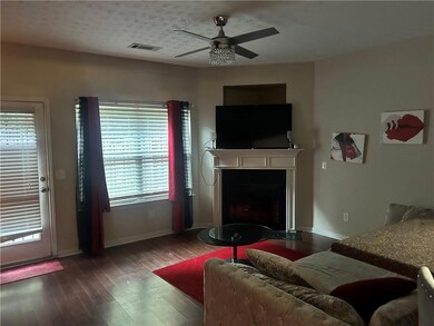 Living room featuring a ceiling fan, wood finished floors, and a fireplace