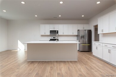 Kitchen with a kitchen island with sink, light woo