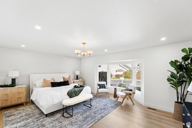Bedroom with recessed lighting, light wood-type flooring, and a chandelier