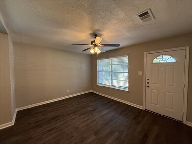 Entryway featuring dark wood-style flooring, a textured ceiling, and ceiling fan