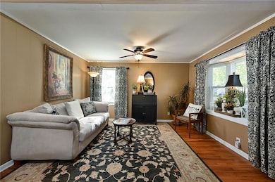 Comfortable living space with hardwood floors, large windows, and warm natural light.