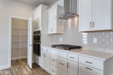 Kitchen with wall chimney range hood, gas stovetop