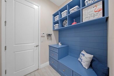 Bright and beachy entryway with wood-look tile and custom built-in mudroom touches.