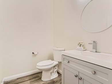 Bathroom featuring vanity, wood finished floors, t