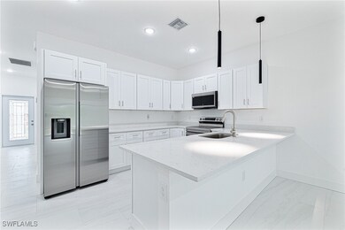 Kitchen with a sink, a peninsula, stainless steel
