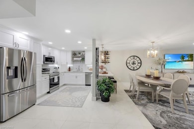Kitchen with stainless steel appliances, open shelves, white cabinetry, recessed lighting, and a chandelier
