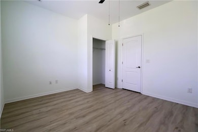 Unfurnished bedroom with wood finished floors, a closet, and a ceiling fan