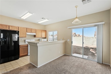 Kitchen with white appliances, a peninsula, under