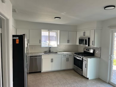 Kitchen with appliances with stainless steel finishes, healthy amount of natural light, and white cabinets