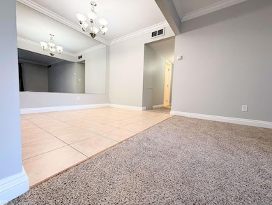 •   Spacious dining area with oversized floor tile, crisp crown molding, and updated lighting.    •   The full wall mirror expands the room visually and brightens the entire space — high-impact and functional for daily living.